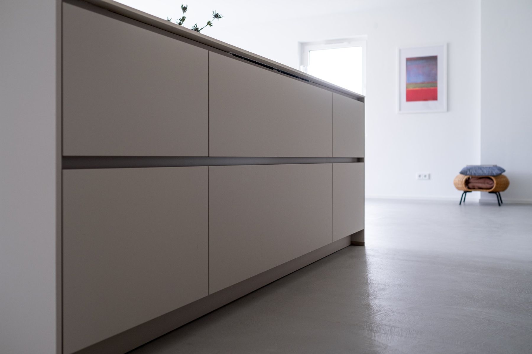 Appartement R, Kücheninsel mit grifflosen Fronten und Blick in den Wohnraum