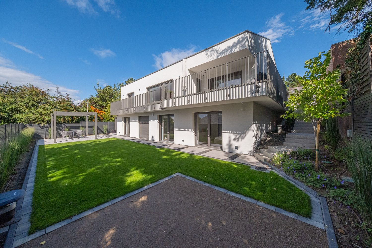 Haus K, Gartenseite mit Rasen und Obergeschoss mit umlaufendem Balkon