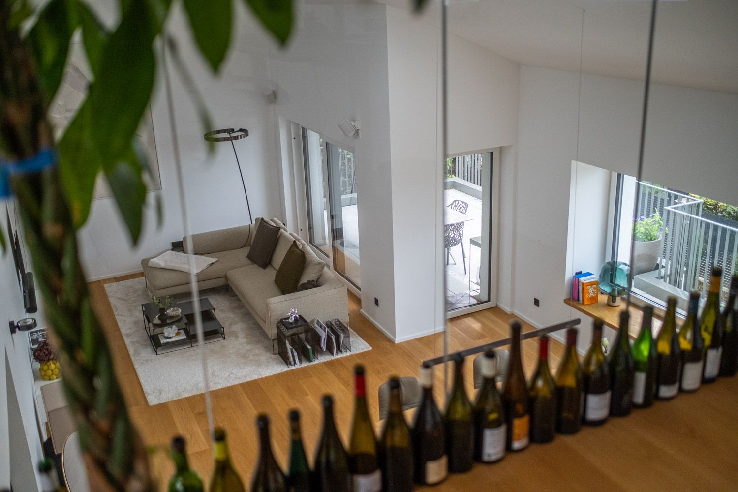 Haus K, Blick von der Galerie in den Wohnbereich, im Vordergrund Weinflaschen