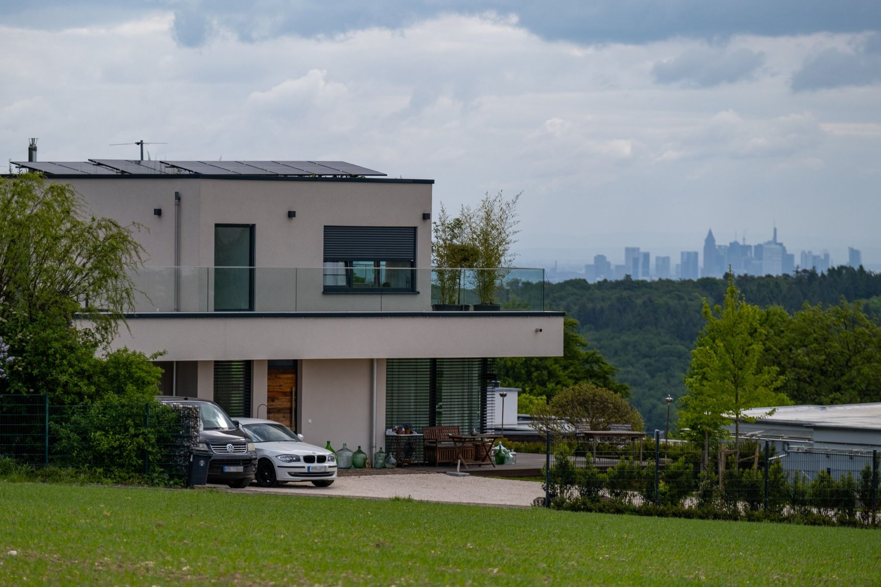 Haus RE, Blick aus dem Feld auf das Haus, im Hintergrund die Frankfurter Skyline