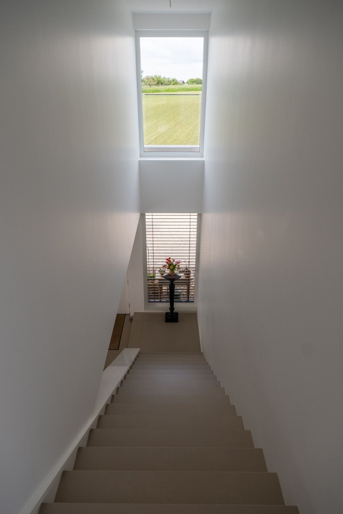 Haus RE, Treppe nach unten mit Oberlicht und Blick auf den Garten