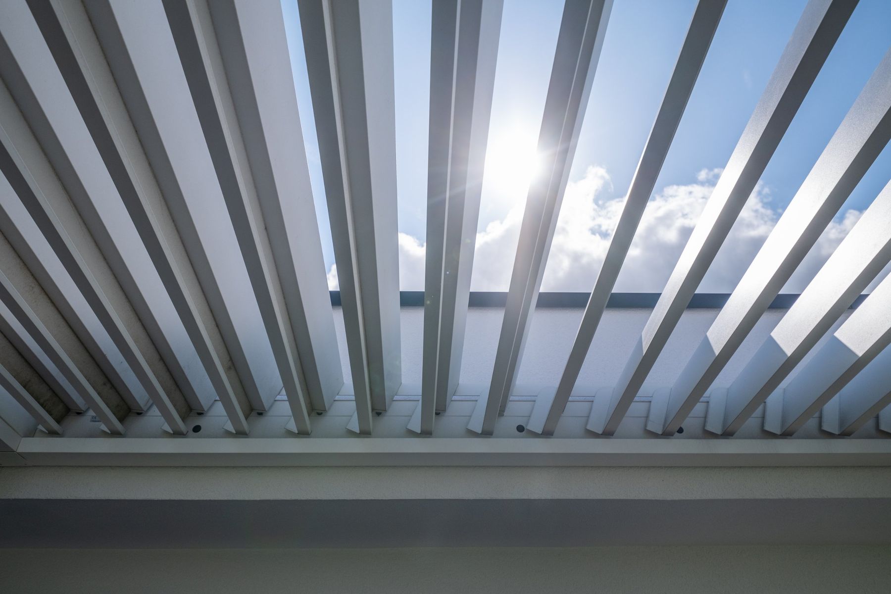 Haus RM, Lamellendach über der Gartenterrasse im Gegenlicht