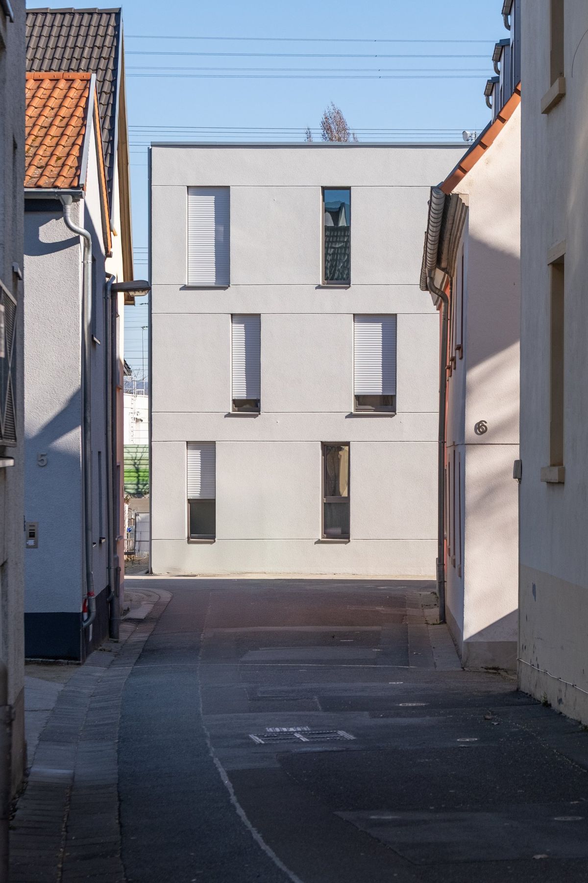 Mehrfamilienhaus K, Blick durch die Gasse auf die Stirnseite des Neubaus