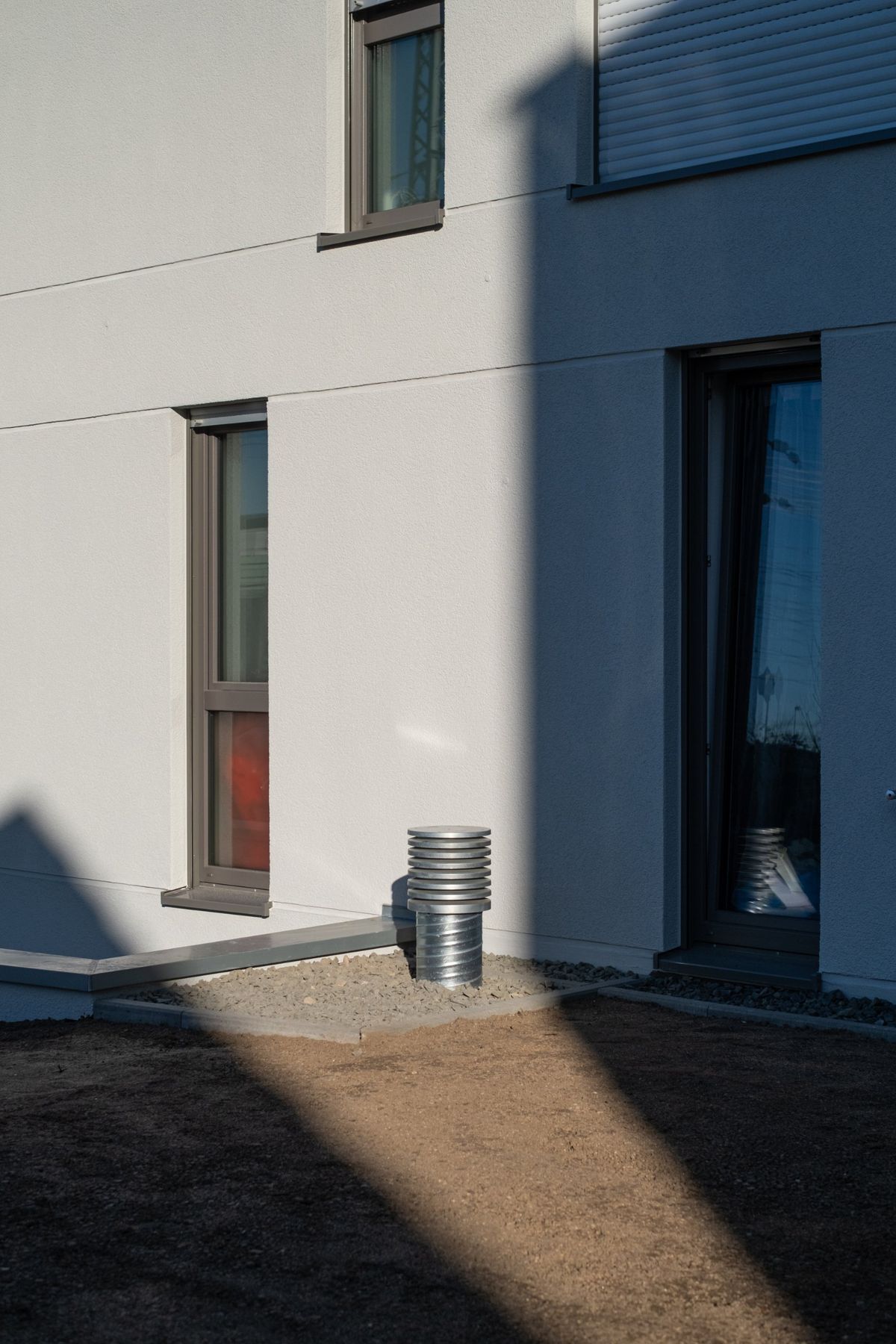 Mehrfamilienhaus K, Fassadendetail mit Fenster und Fensterbändern im Schlagschatten